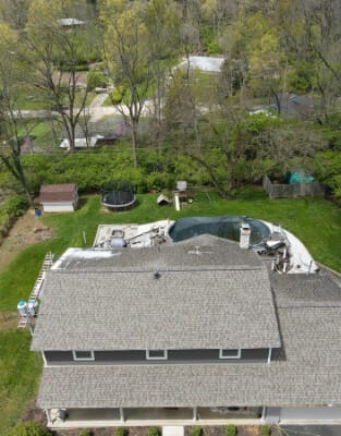 Aerial view of suburban home with swimming pool and landscaped backyard