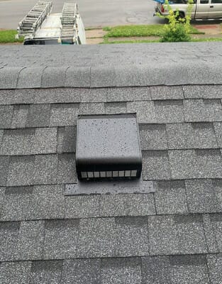 Gray roof vent installed on asphalt shingle roof for proper attic ventilation