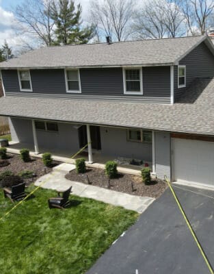 Modern two-story gray house with white trim and landscaped front yard