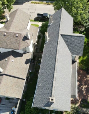 Aerial view of residential homes with asphalt shingle roofs in suburban neighborhood