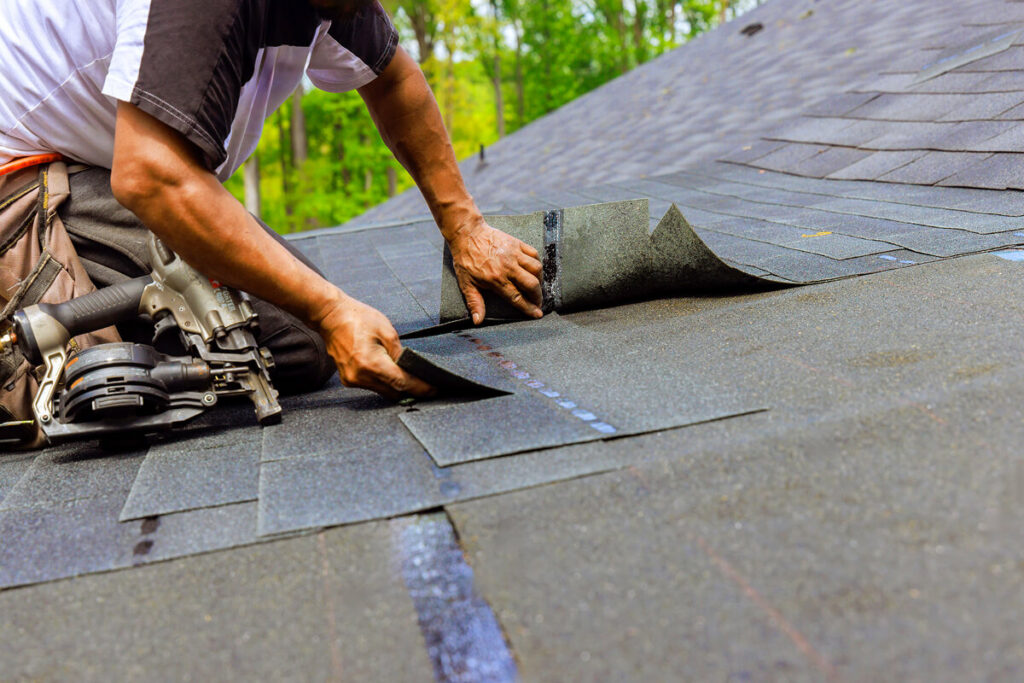 How Long Do Composite Roofs Last Roofer installing asphalt shingles on a residential roof.