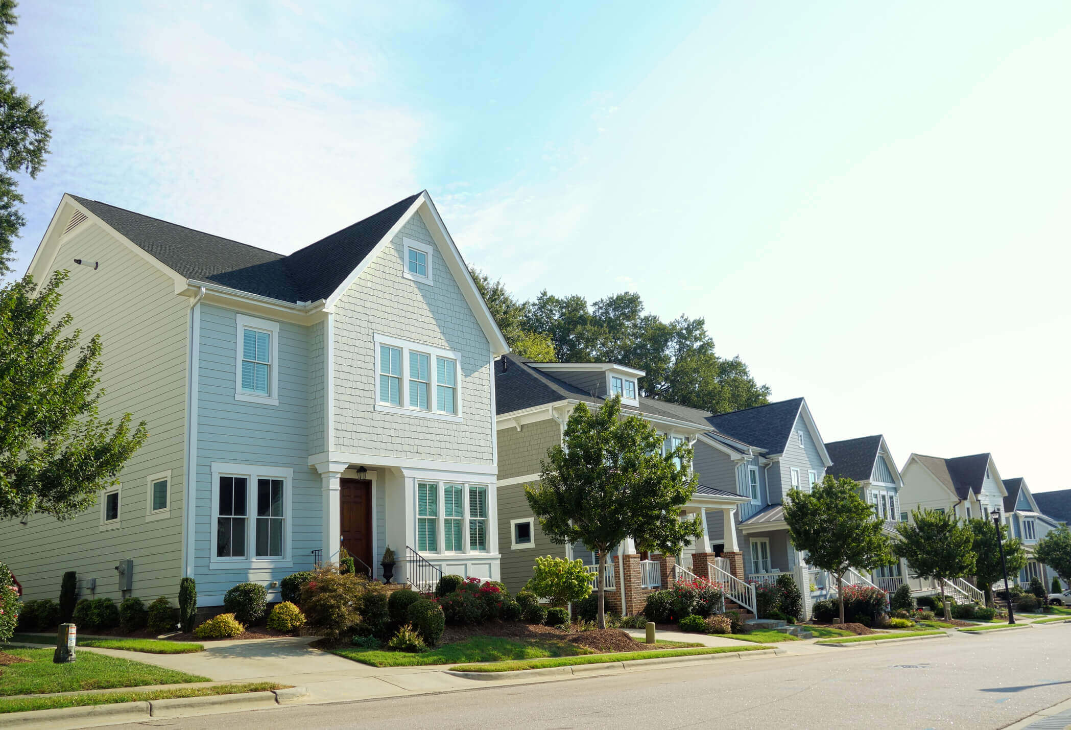 Modern suburban homes with colorful siding and front porches in residential neighborhood
