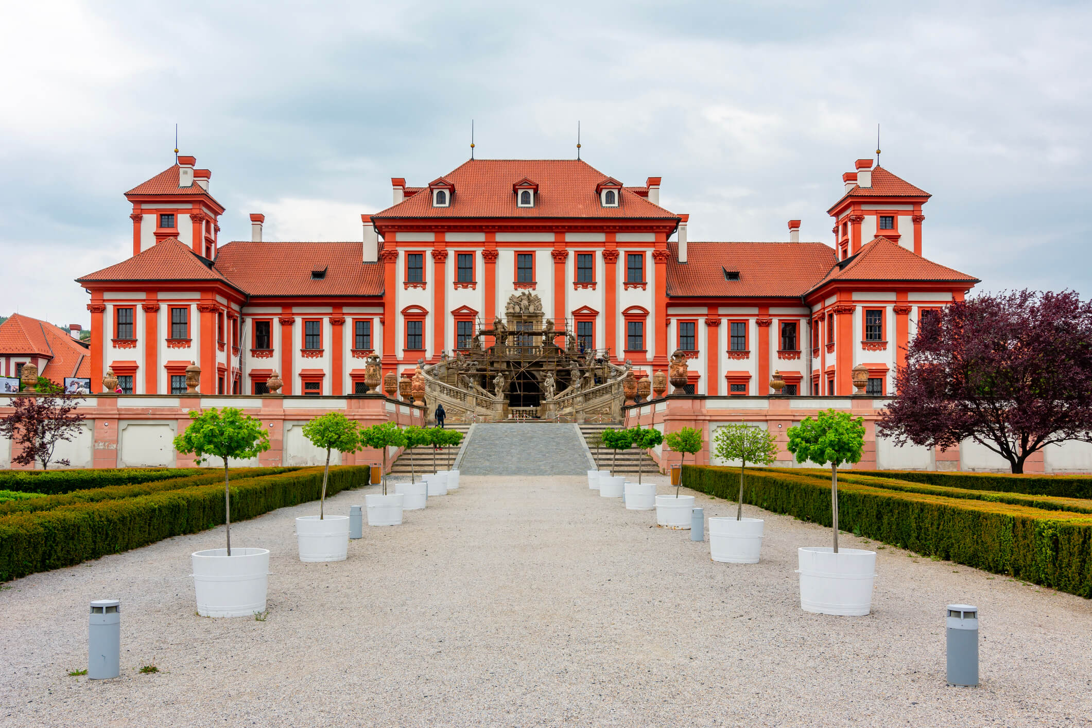 Historic red baroque palace with ornate architecture and formal gardens