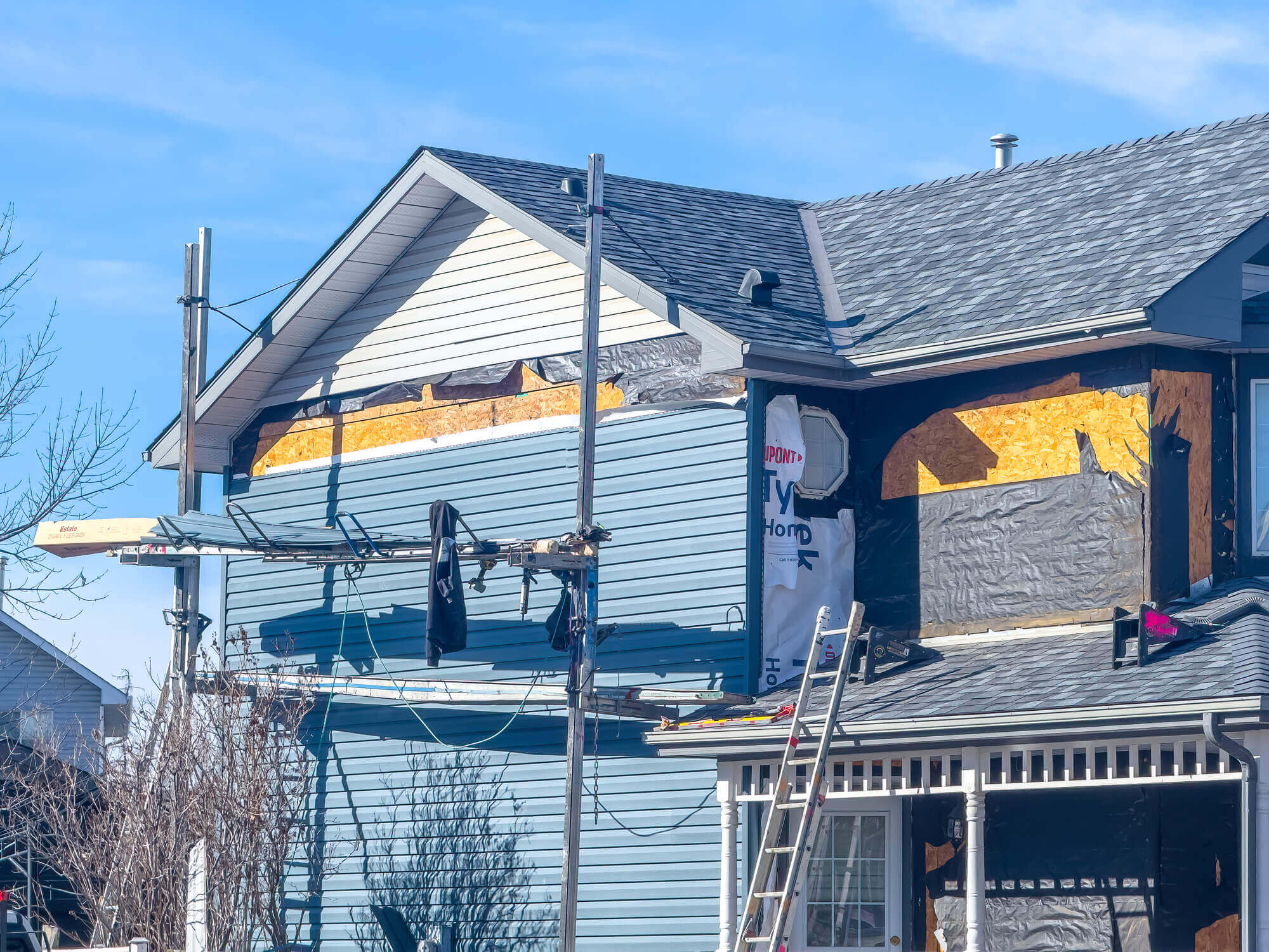 House siding renovation with scaffolding and exposed insulation materials